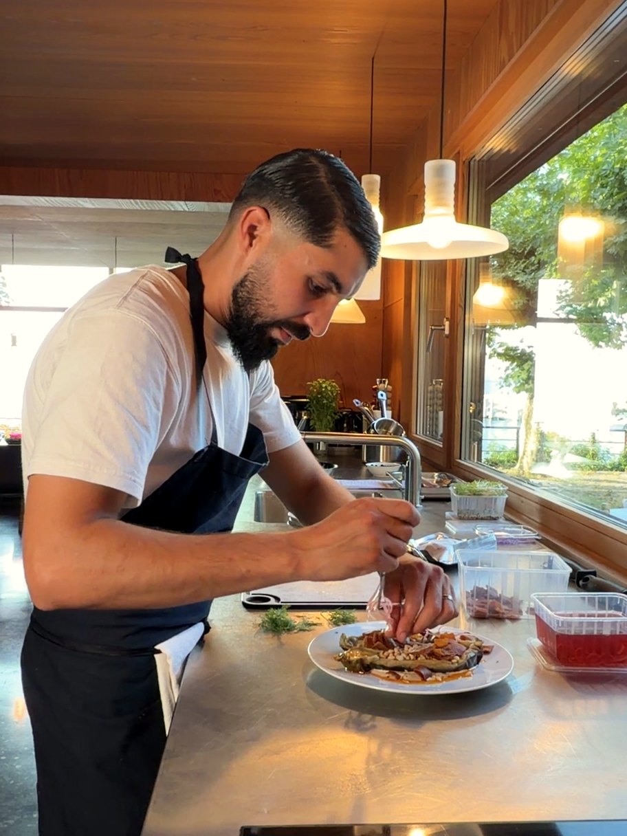 Le Chef Yazid Nassime dressant une assiette dans une cuisine ouverte